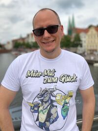 Daniel Korth mit T-Shirt "Mehr Mut zum Glück"
