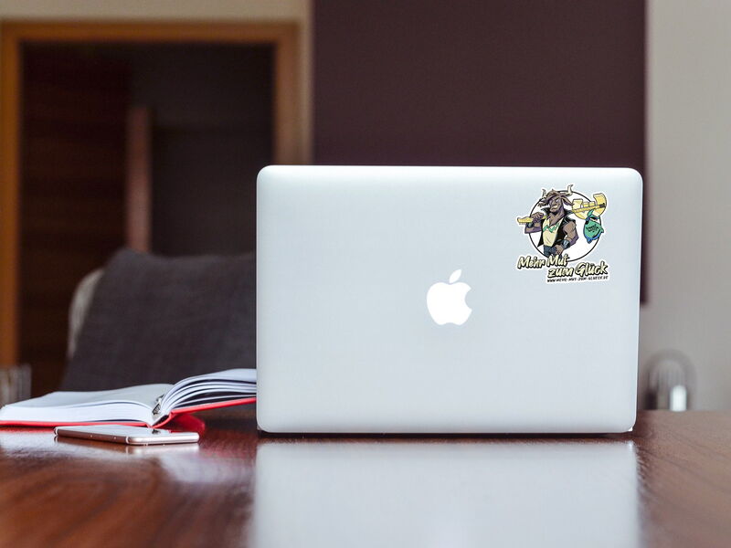 Aufkleber "Mehr Mut zum Glück" auf einem Laptop